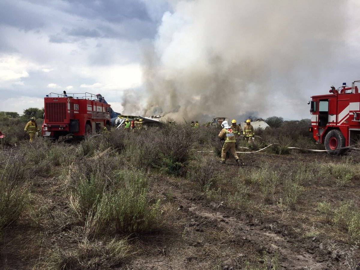 Firefigters and rescue personnel work at the site where an Aeromexico-operated Embraer passenger jet crashed in Mexico's northern state of Durango