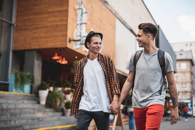 Happy man holding hand of outgoing friend