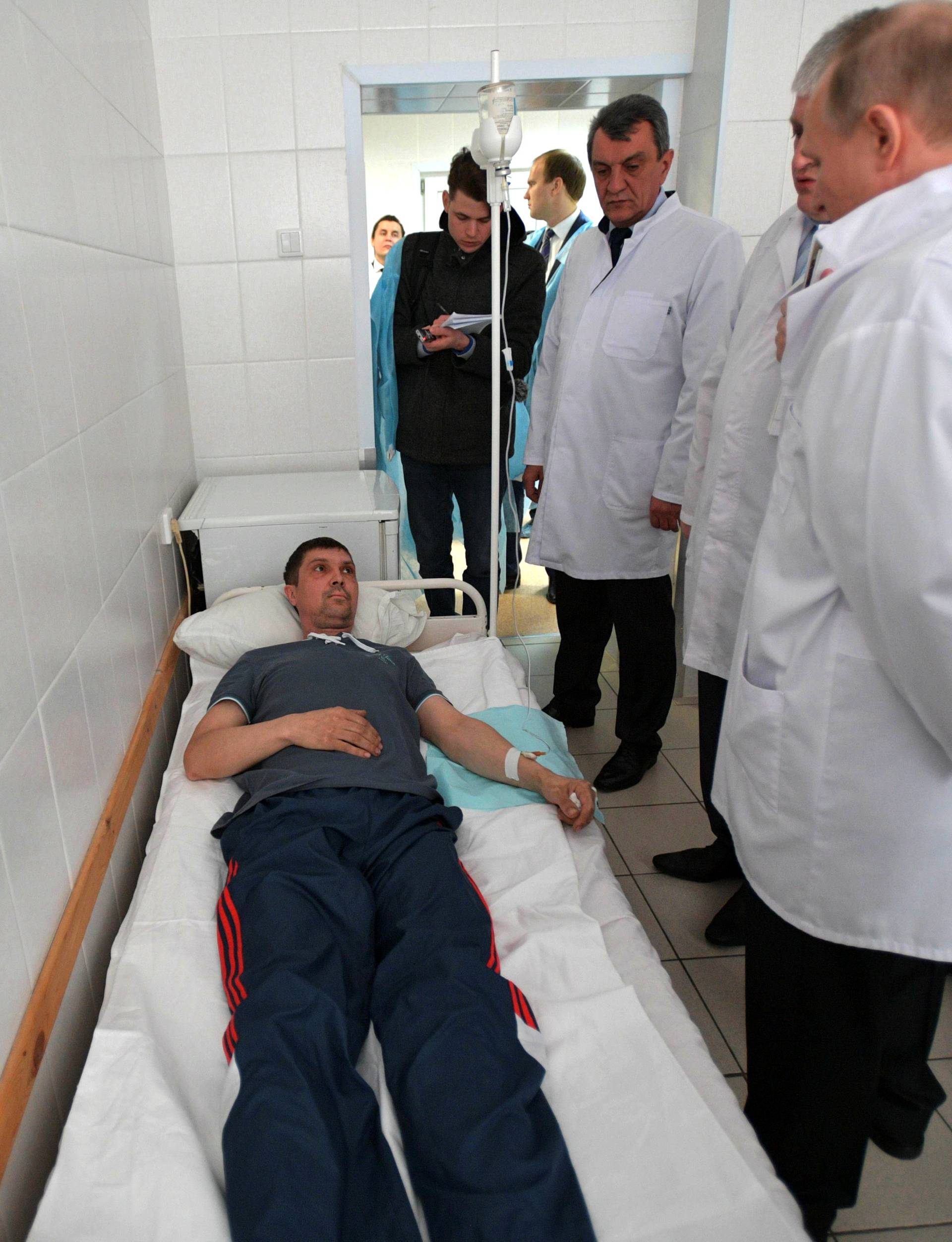 Russian President Vladimir Putin meets with victims injured during a fire in a shopping mall, at a hospital in Kemerovo