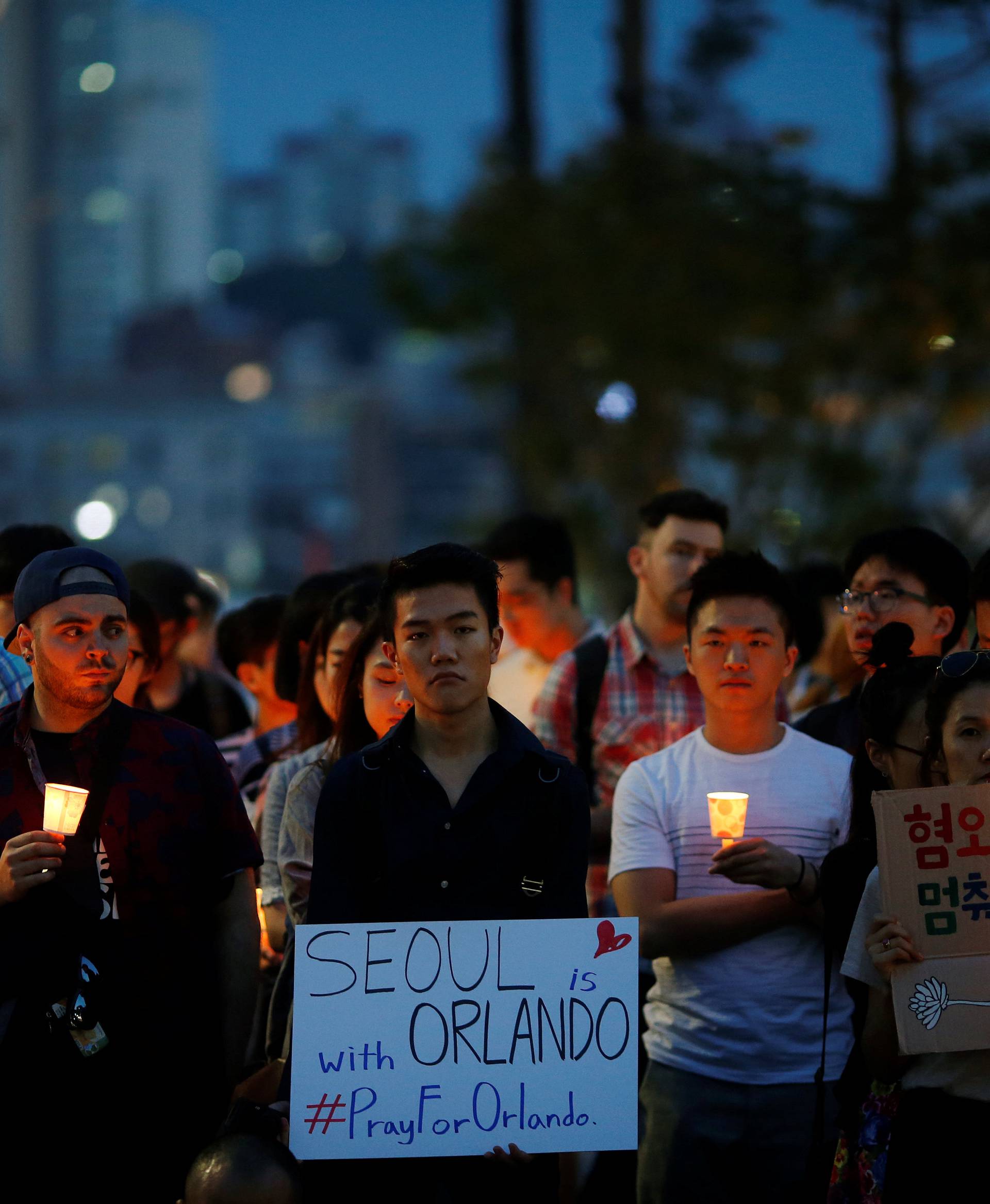 People attend a candlelight vigil in solidarity for the victims of the Orlando gay nightclub mass shooting in Seoul