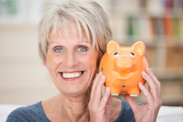 Excited,Senior,Woman,Holding,Up,Her,Piggy,Bank,Smiling,In