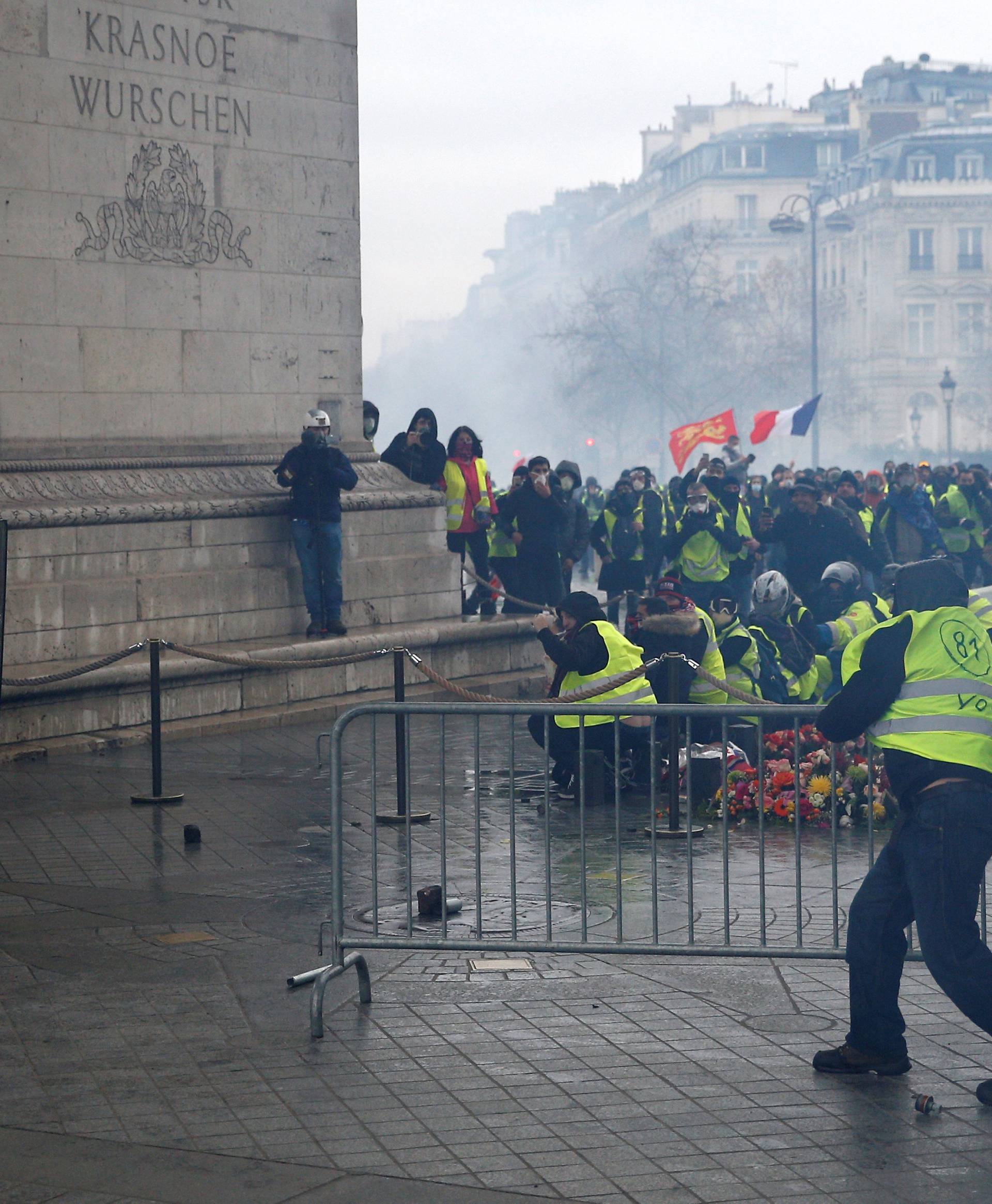 Protesters wearing yellow vests, a symbol of a drivers' protest against higher diesel taxes, face off with riot police near the Tomb of the Unknown Soldier at the Arc de Triomphe during clashes at the Place de l'Etoile in Paris