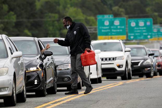 Scores of vehicles line up to enter a gasoline station during surge in demand for fuel in Durham, North Carolina
