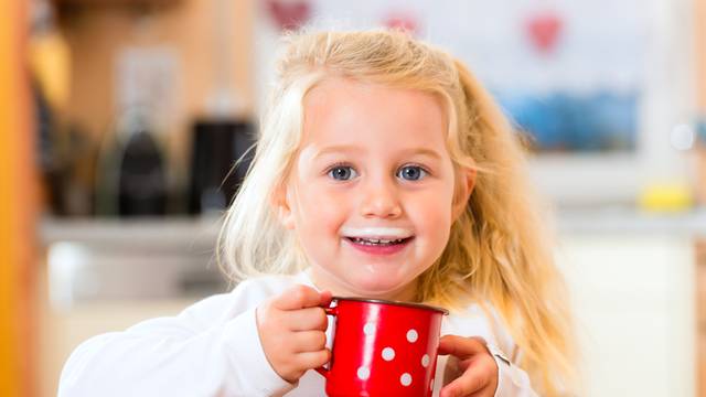 Girl drinking milk in kitchen