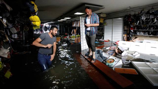 Shopkeepers try to save their goods at a flooded underground passage following heavy rains in Istanbul