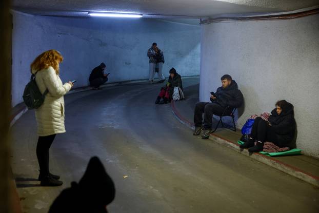 People take shelter inside an underground parking lot during a Russian missile and drone attack in Kyiv