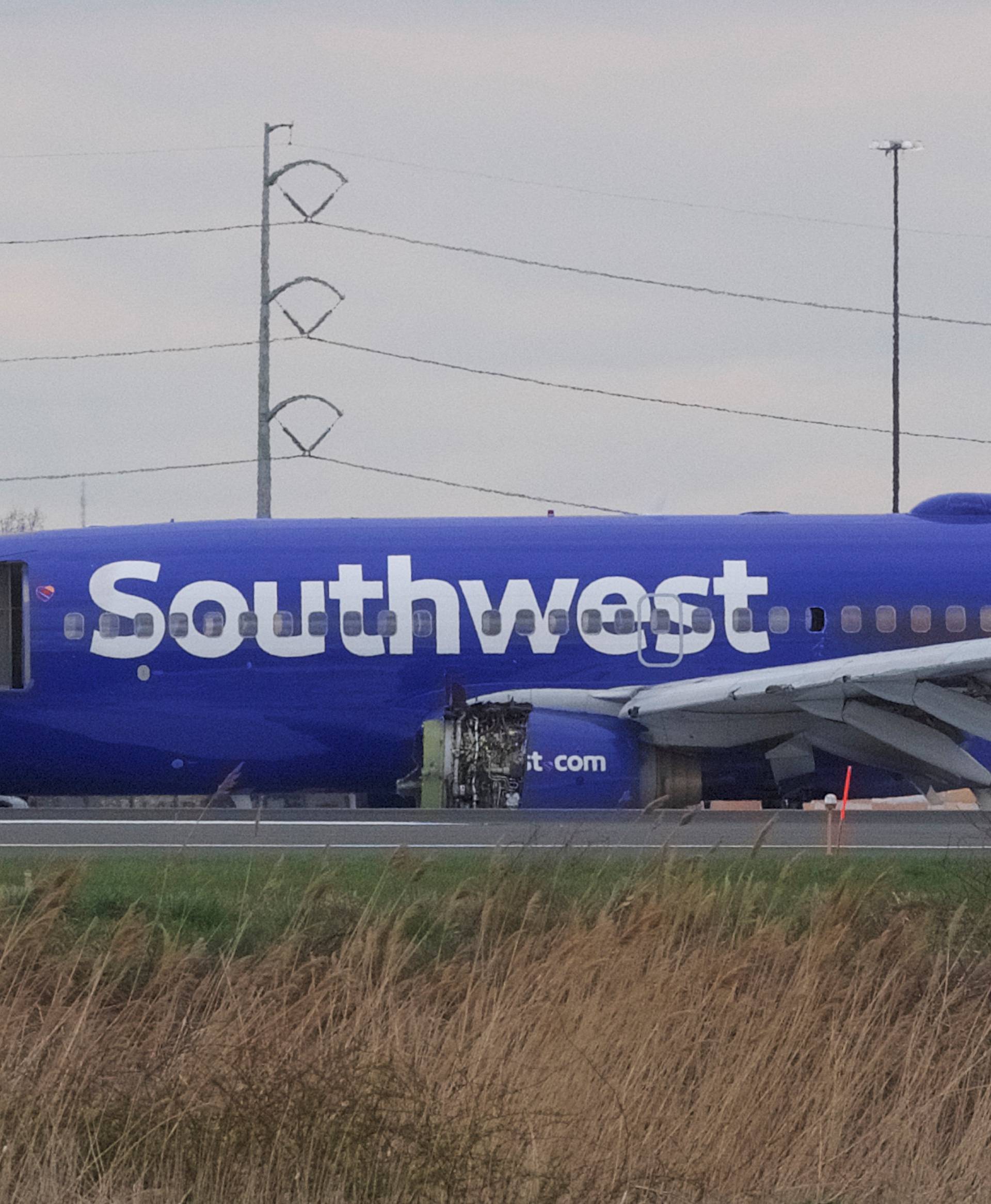 Emergency personnel monitor the damaged engine of Southwest Airlines Flight 1380, which diverted to the Philadelphia International Airport this morning, in Philadelphia, Pennsylvania