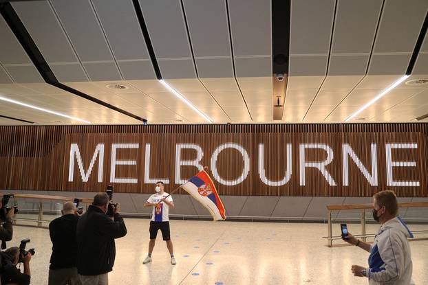 A Serbian fan waits for Novak Djokovic at Melbourne Airport