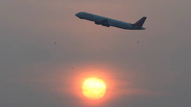 FILE PHOTO: An Air India passenger plane passes the sun on a smoggy morning in Ahmedabad