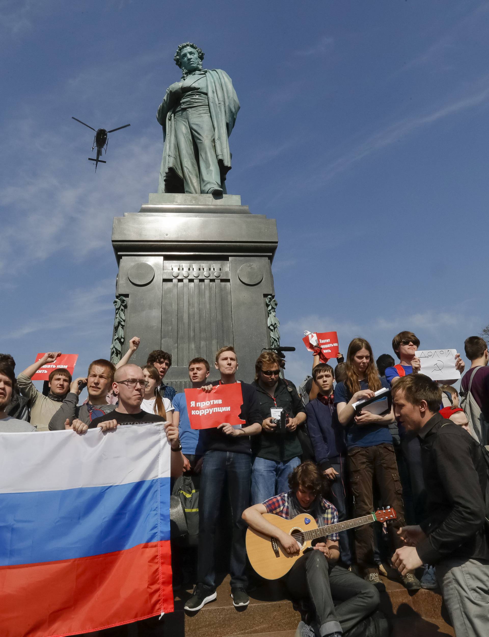 A helicopter flies above as opposition supporters attend a protest rally in Moscow