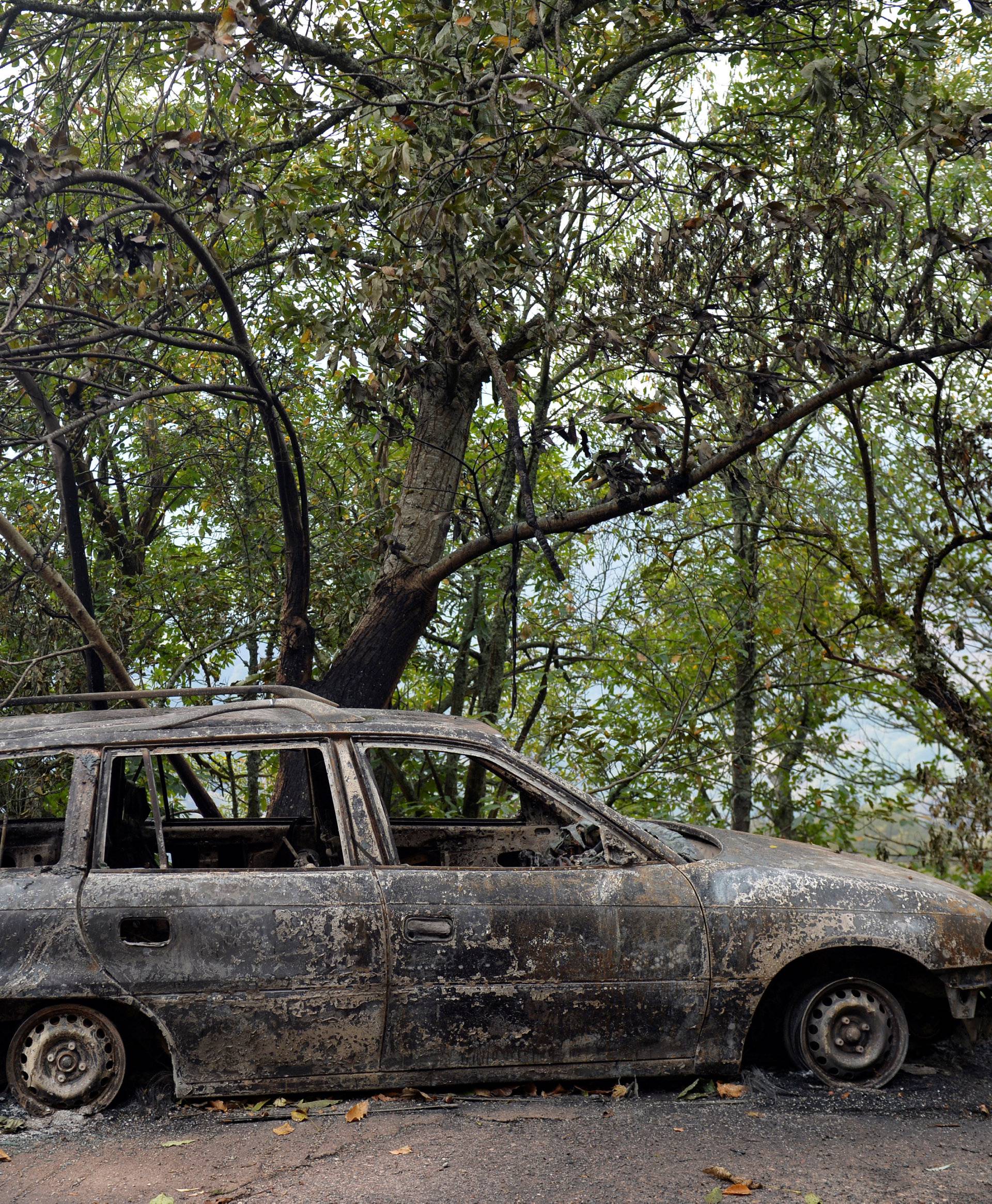 A car burnt by forest fire is seen in San Martin de Cereixedo in Galicia