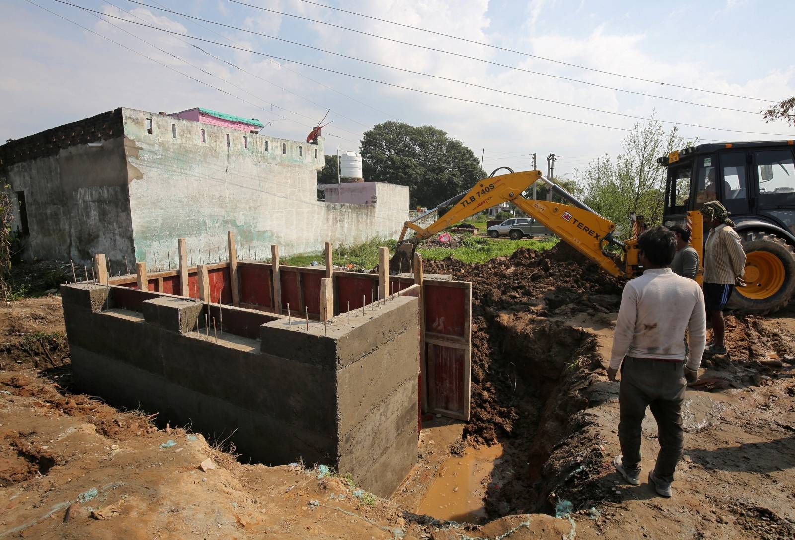 Workers construct a concrete bunker in a residential area near the border with Pakistan in Samba sector
