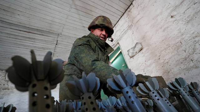 A service member of pro-Russian troops in uniform without insignia is seen at the weapons depot near Marinka