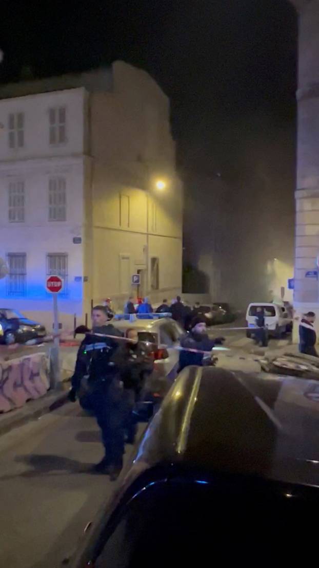 Smoke envelopes the area as police officers work at the scene of a fire following a gas explosion in Marseille