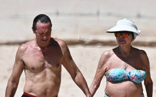 *PREMIUM-EXCLUSIVE* *MUST CALL FOR PRICING* The British Actress, 90-year-old Joan Collins and her husband Percy Gibson enjoy an affectionate stroll as they held hands at the beach on their Caribbean getaway in Western Barbados.*PICTURES TAKEN ON 31/10/20