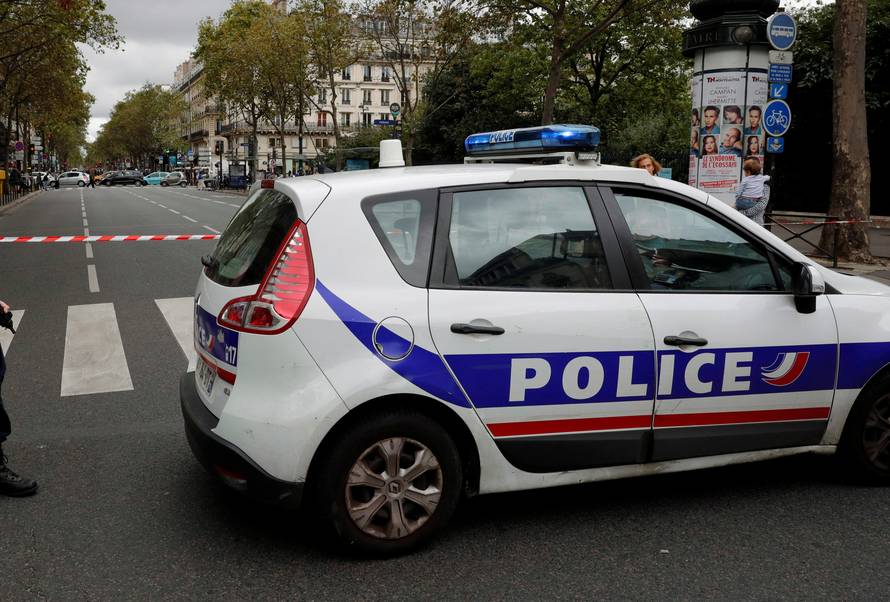 French police secure the area next to a church during a security operation in a shopping district of Paris