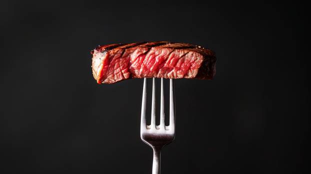 Fork with slices of beef steak medium rare, black clean background. Aesthetic restaurant concept. Generative AI