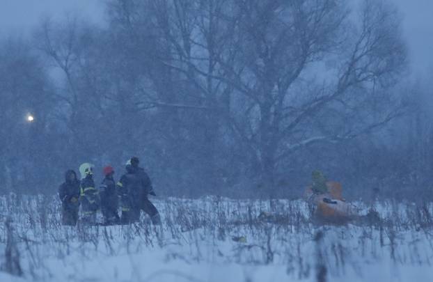 Emergency services work at the scene where a short-haul regional Antonov AN-148 plane crashed after taking off from Moscow
