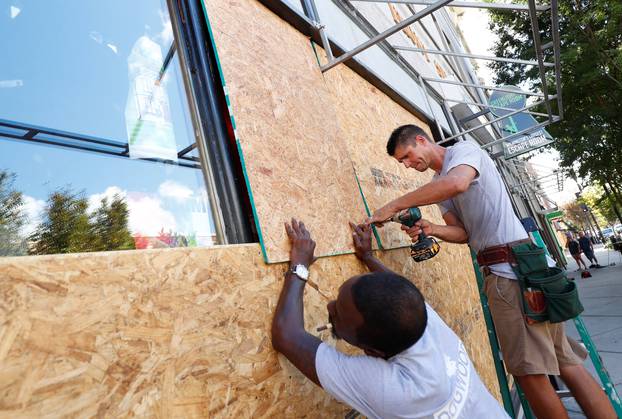 Workers are seen as they work to secure plywood ahead of the arrival of Hurricane Florence