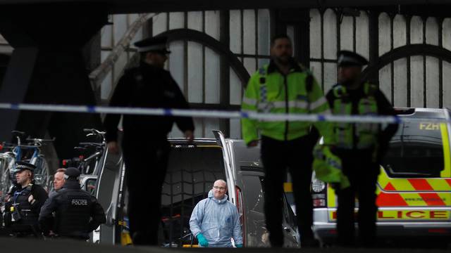 Police officers including one wearing a forensic suit, are seen in a cordoned off area at Waterloo station near to where a suspicious package was found, in London