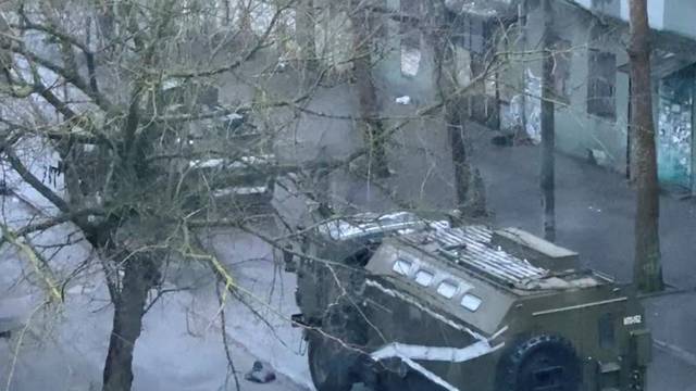 A military truck and tank are seen on a street of Kherson