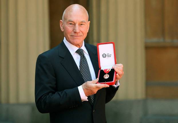 FILE PHOTO: Actor Patrick Stewart poses with his knighthood after he was knighted by Britain's Queen Elizabeth at Buckingham Palace in London
