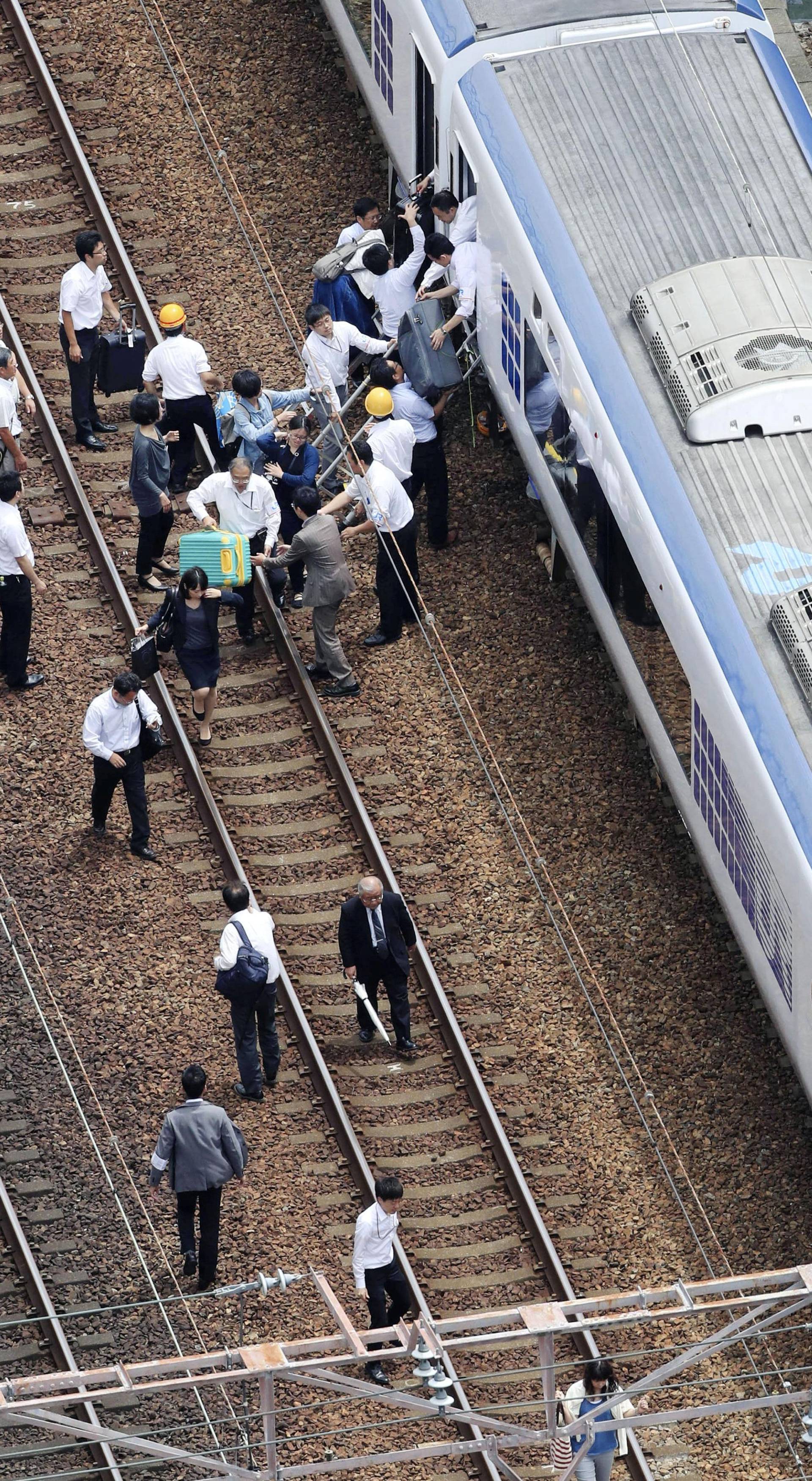 Passengers get off a train which operation was suspended after an earthquake in Takatsuki