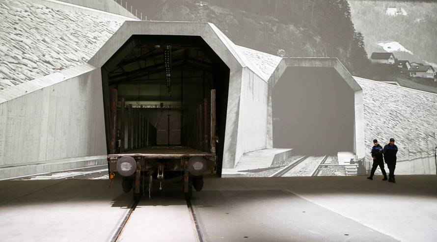 Swiss police officers stand beside of mock gates of the NEAT Gotthard Base Tunnel inside the event hall for the upcoming opening ceremony near the town of Erstfeld