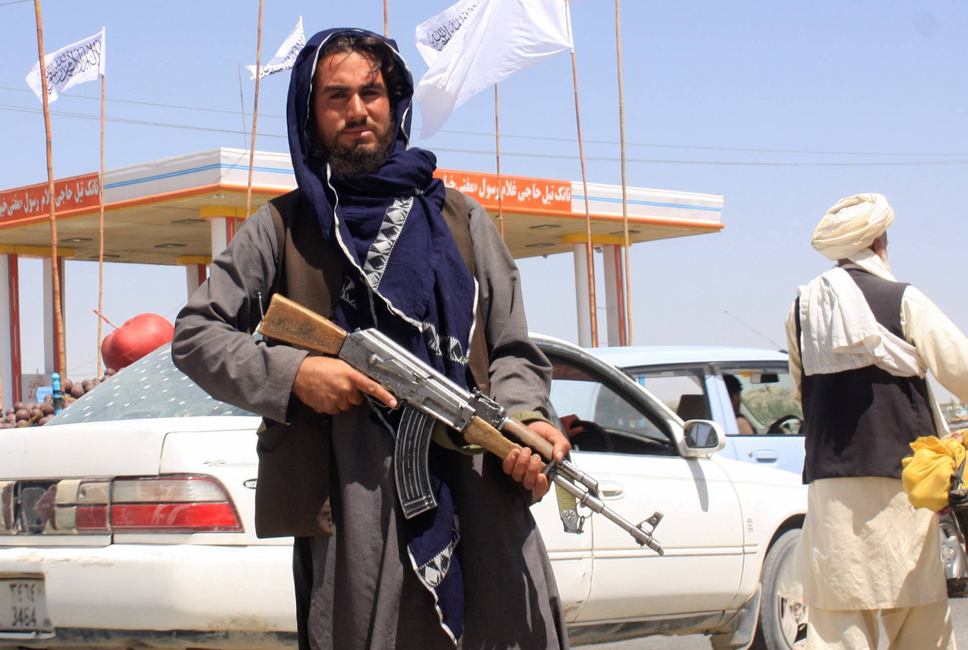 A Taliban fighter looks on as he stands at the city of Ghazni