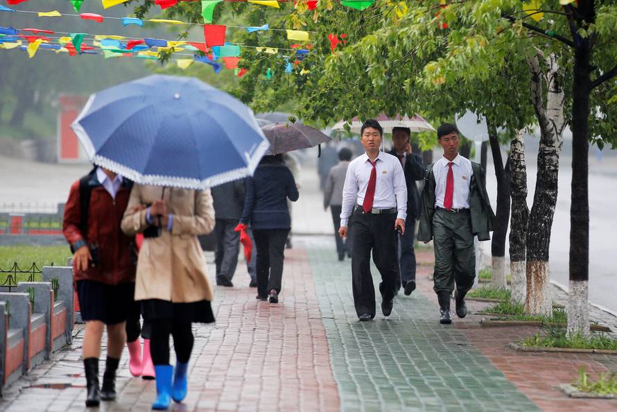 People walk in the rain near April 25 House of Culture, the venue of Workers' Party of Korea (WPK) congress in Pyongyang