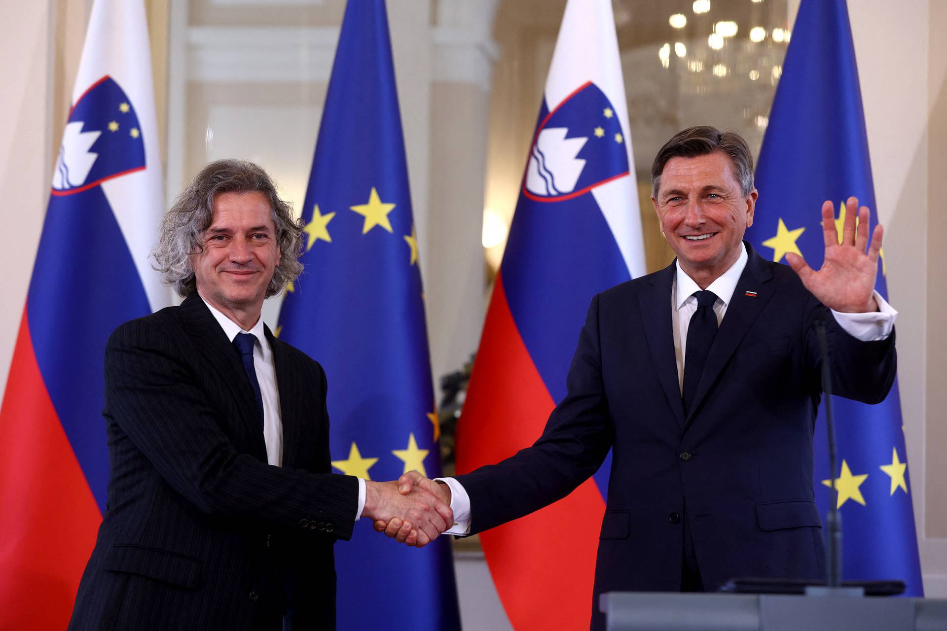 Slovenia's President Borut Pahor and the winner of Parliamentary elections Robert Golob shake hands after a new conference in Ljubljana