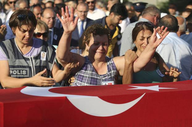 Women mourn over the coffin holding body of police officer Nedip Cengiz Eker during a funeral ceremony in Marmaris