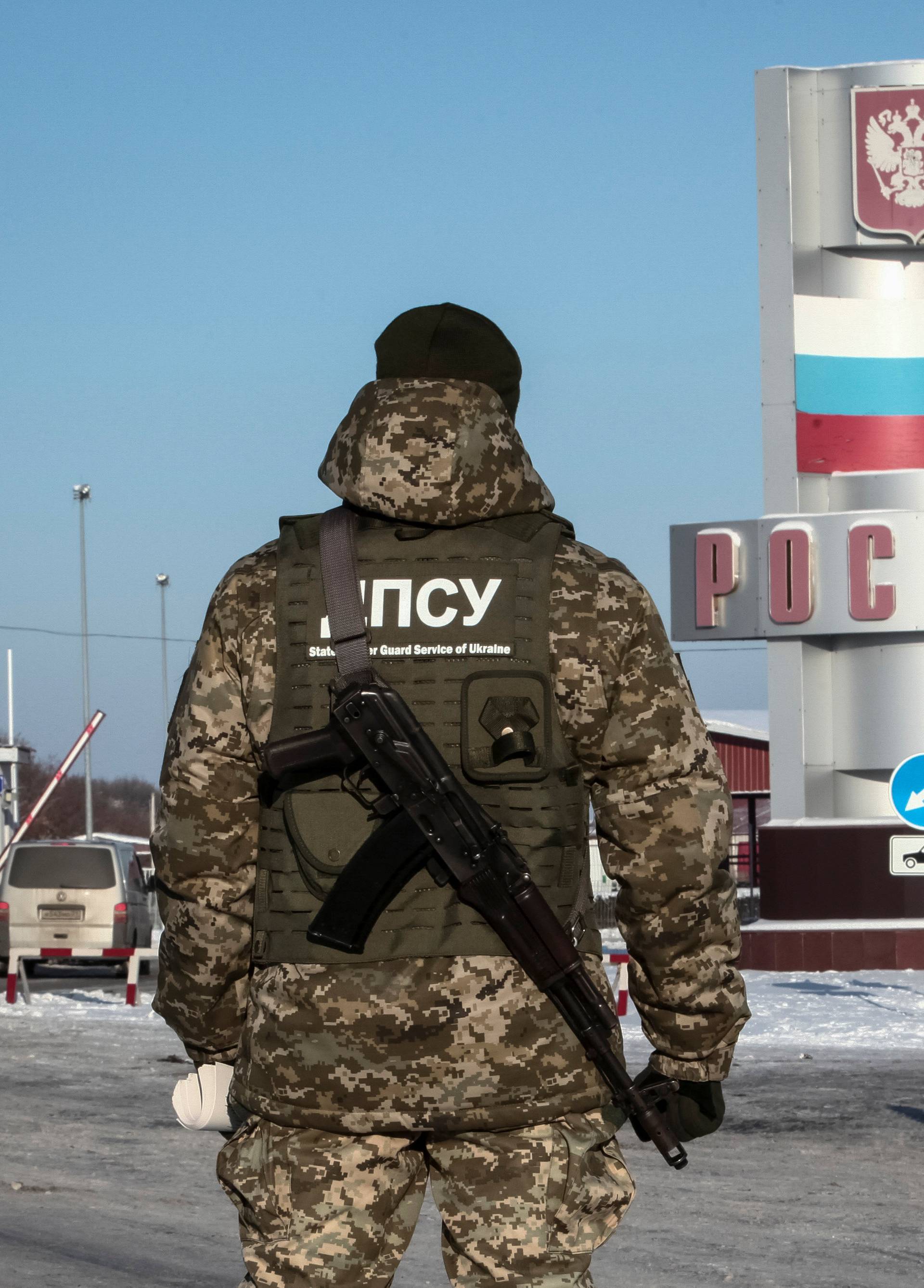 A member of the Ukrainian State Border Guard Service stands guard at a crossing point on the border between Russia and Ukraine in Kharkiv Region