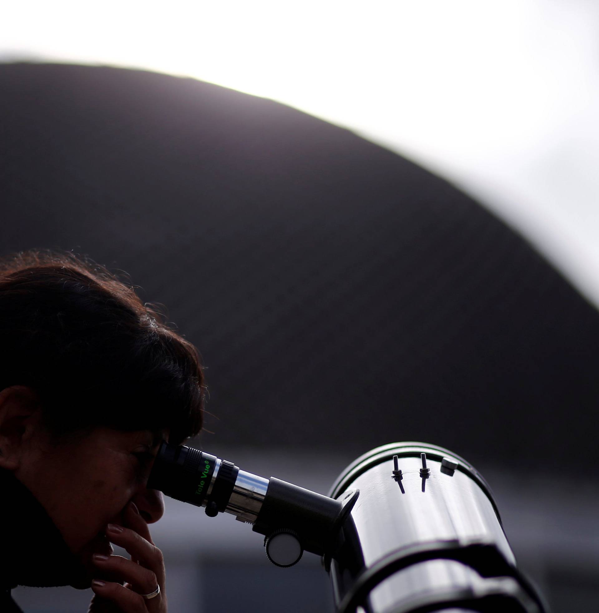 A woman uses a telescope to observe the planet Mercury transit in front of the sun outside Buenos Aires' planetarium
