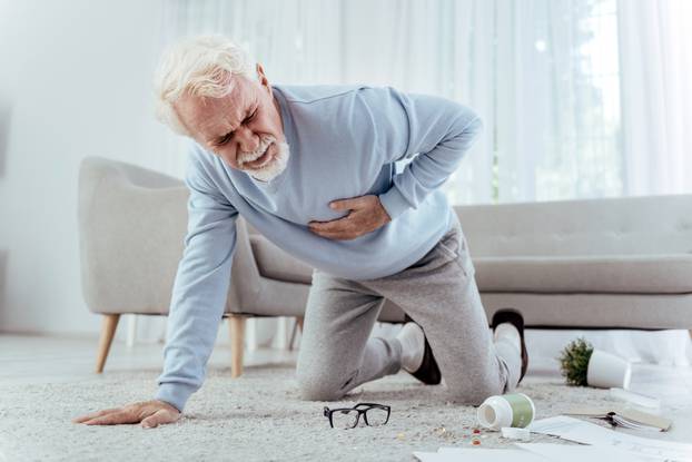 Sick senior man falling from heart attack