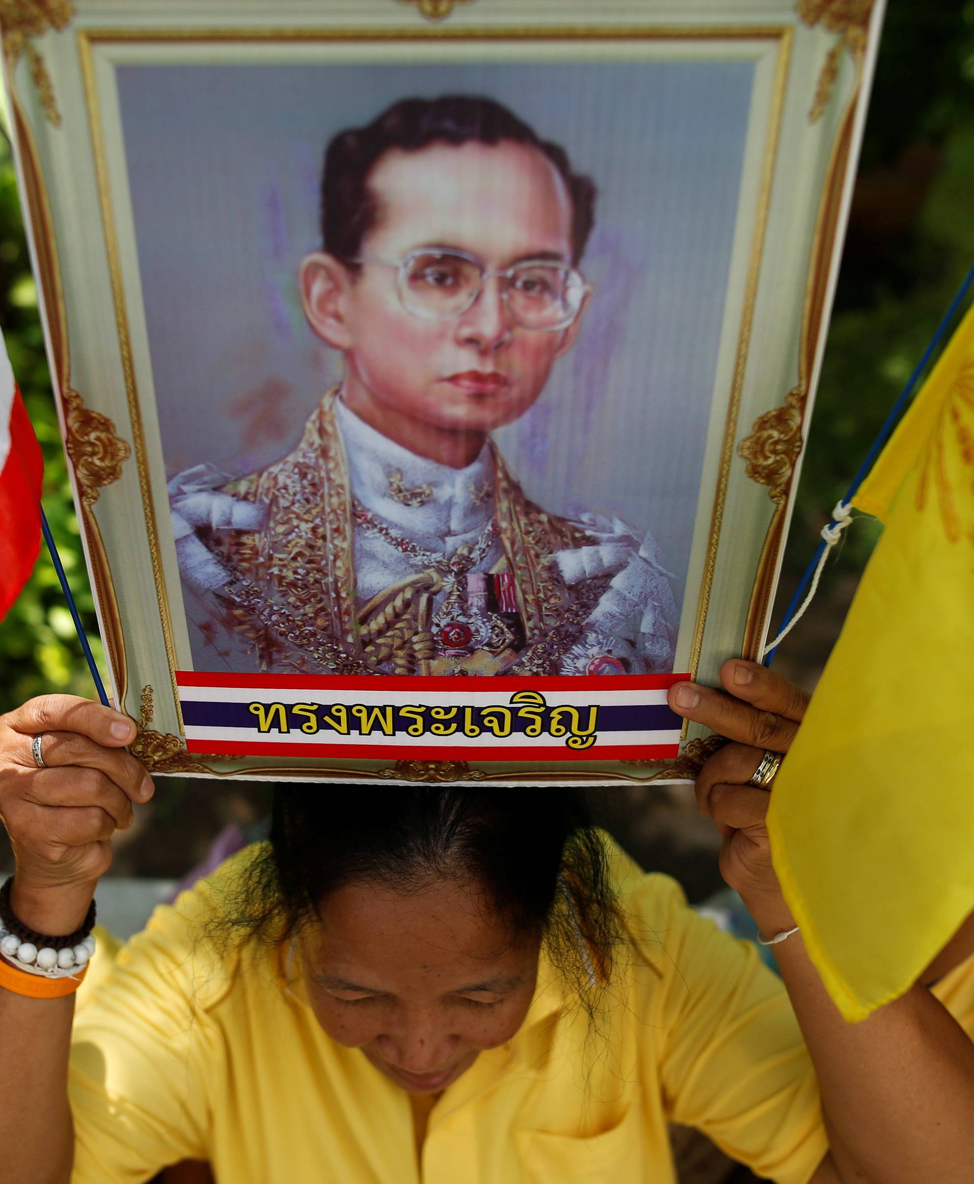 Well-wishers hold a picture of Thailand's King Bhumibol Adulyadej at the Siriraj hospital where he is residing, in Bangkok