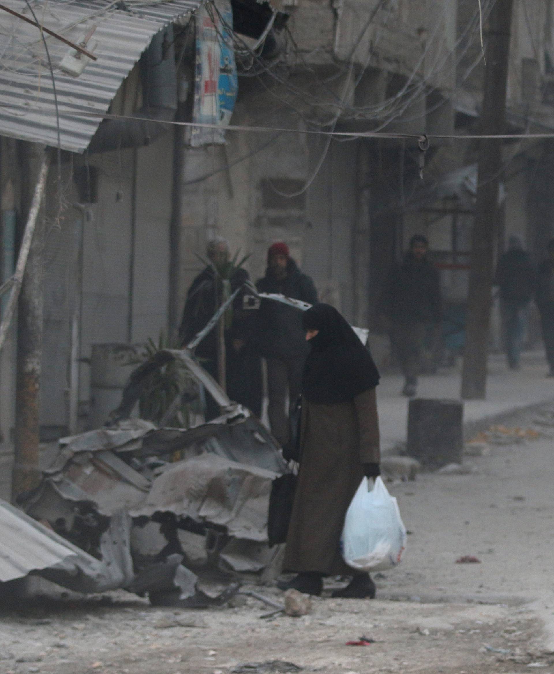 People carry their belongings as they flee deeper into the remaining rebel-held areas of Aleppo