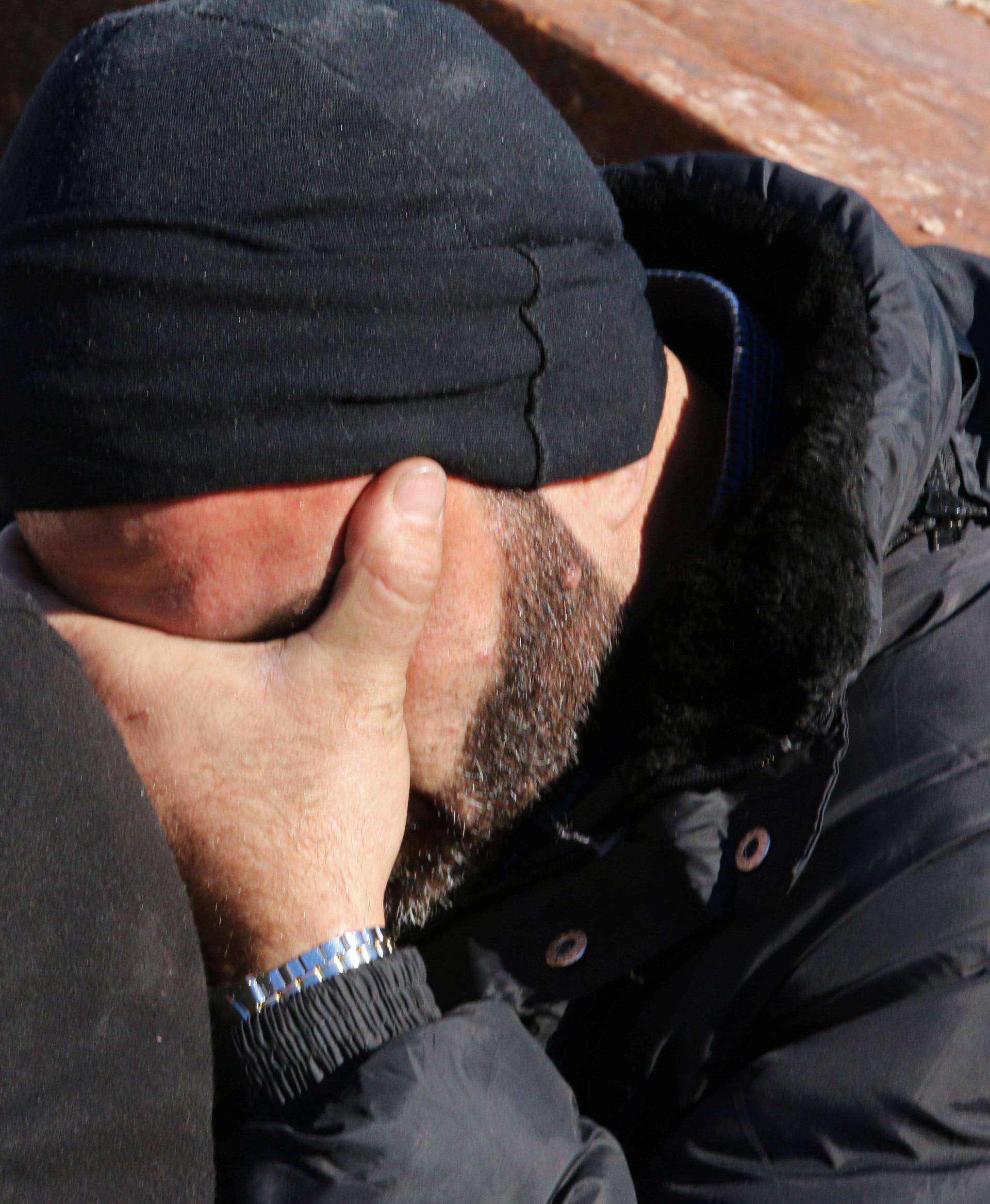 A man reacts as he waits with others to be evacuated from a rebel-held sector of eastern Aleppo