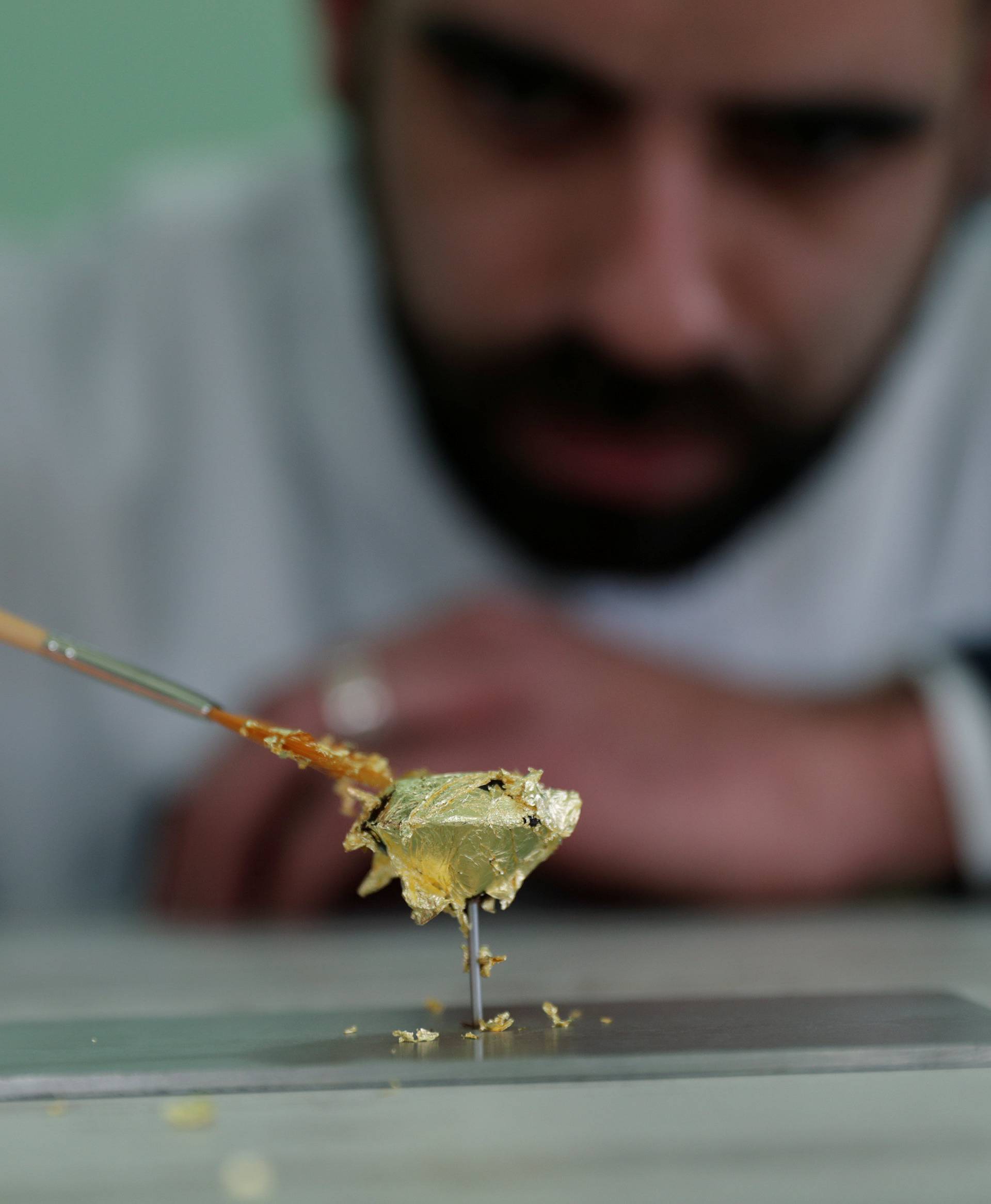 Portuguese chocolatier Daniel Gomes prepares a candy wrapped in pure 23 carat gold during international chocolate fair in Obidos