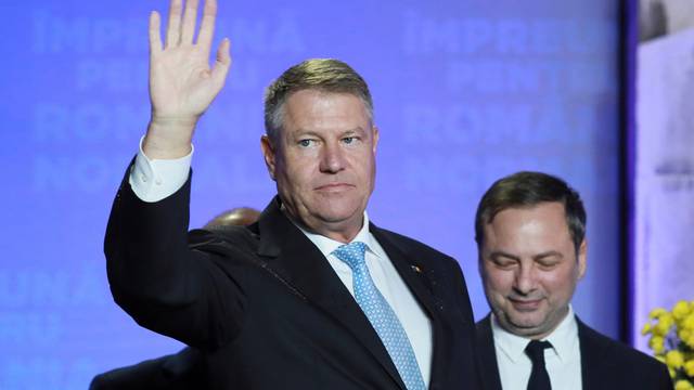 Incumbent candidate Klaus Iohannis waves during a news conference that marked the end of the first round of the presidential election, in Bucharest