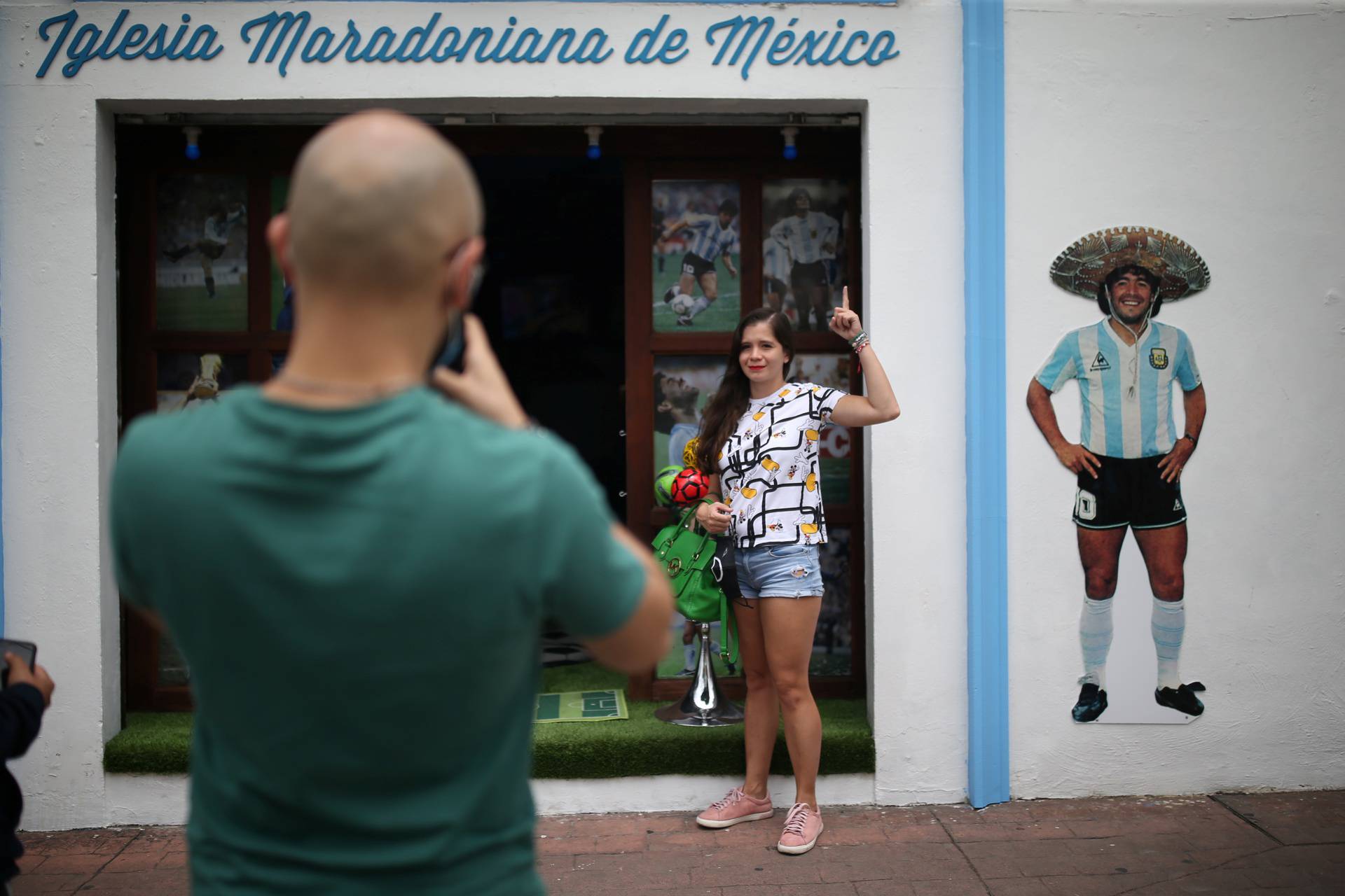 A fan takes photos at the entrance to the first Mexico's church in memory of soccer legend Diego Armando Maradona in San Andres Cholula