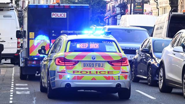A police prison van under escort leaves Westminster Magistrates' Court in London
