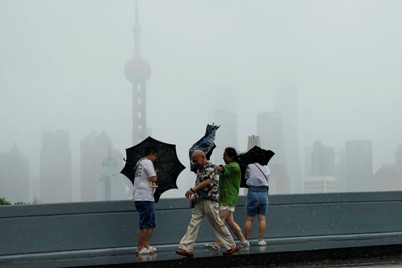 People walk in the rainstorm as typhoon Lekima approaches in Shanghai