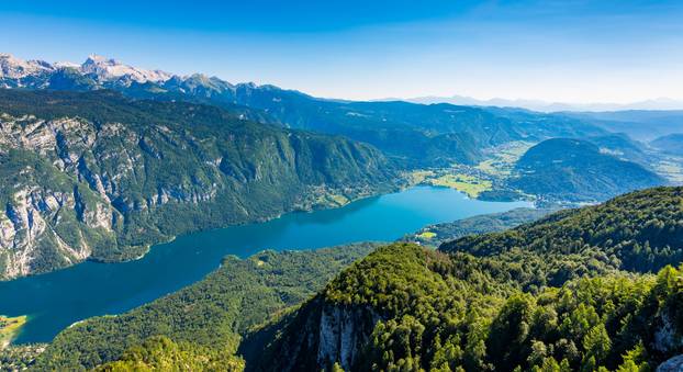 Aerial view of Bohinj lake from Vogel cable car station. Mountains of Slovenia in Triglav national park. Julian alps landscape. Blue water, summer sky, mountains in the bakcground