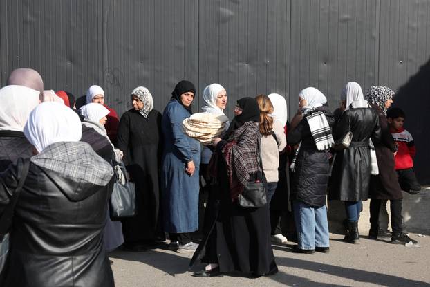 People queue to buy bread in Damascus