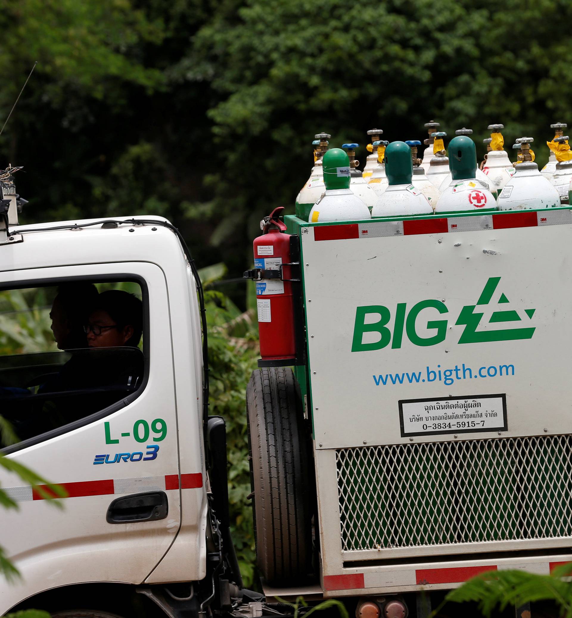 Rescue worker travel on a vehicle loaded with oxygen tanks near the Tham Luang cave complex in the northern province of Chiang Rai