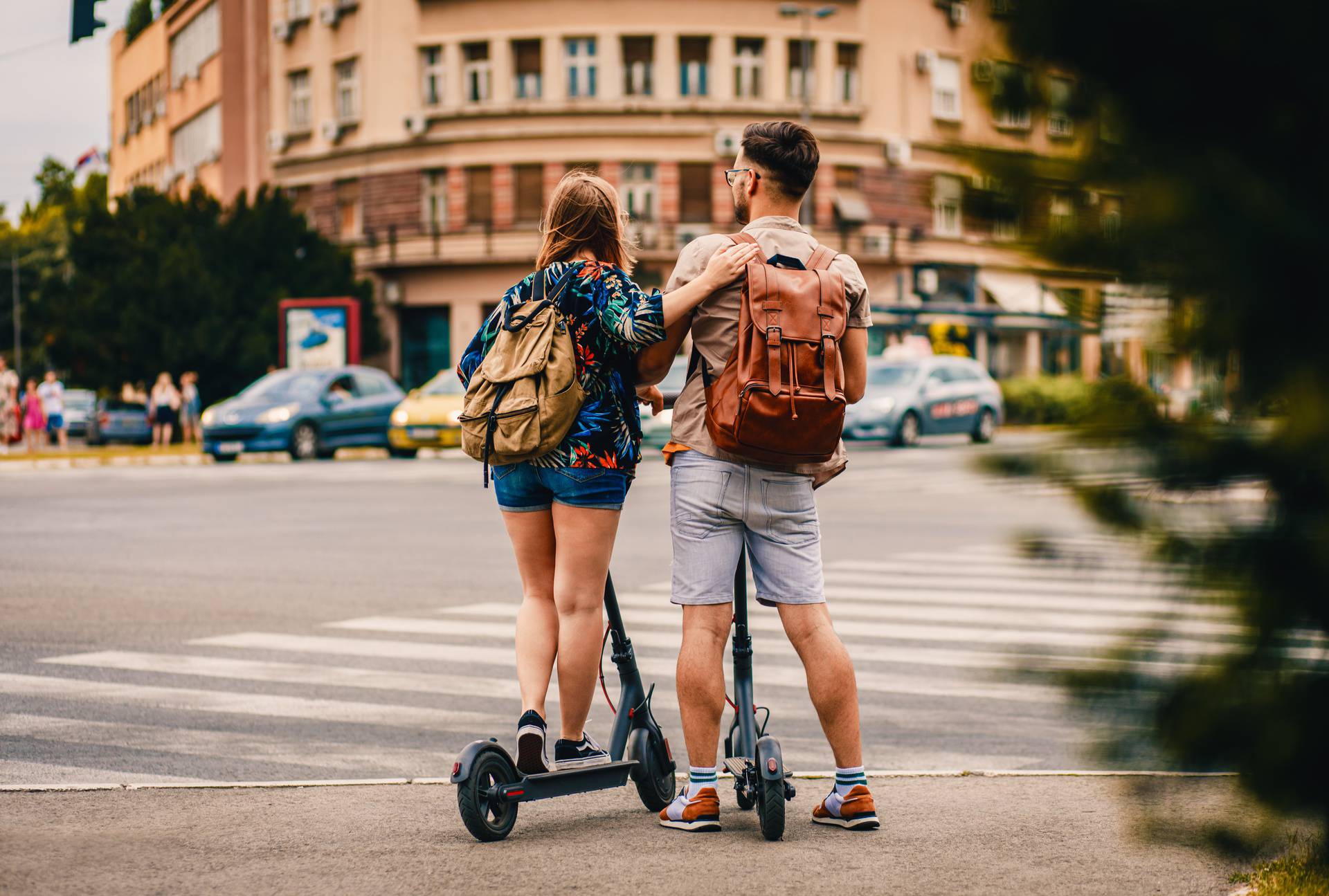 Young,Couple,On,Vacation,Having,Fun,Driving,Electric,Scooter,Through