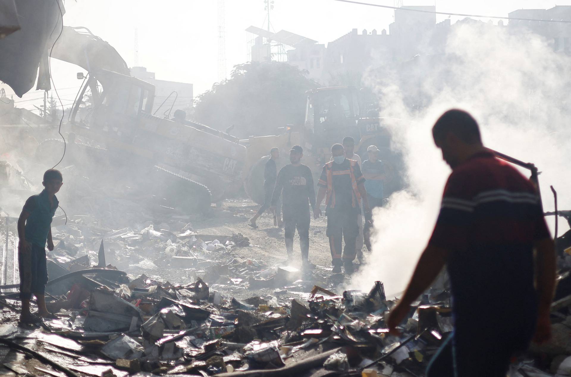 A Palestinian firefighter walks at the of Israeli strikes on a residential building in Khan Younis