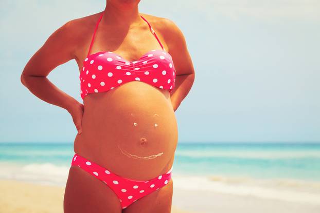 Happy pregnant woman at beach