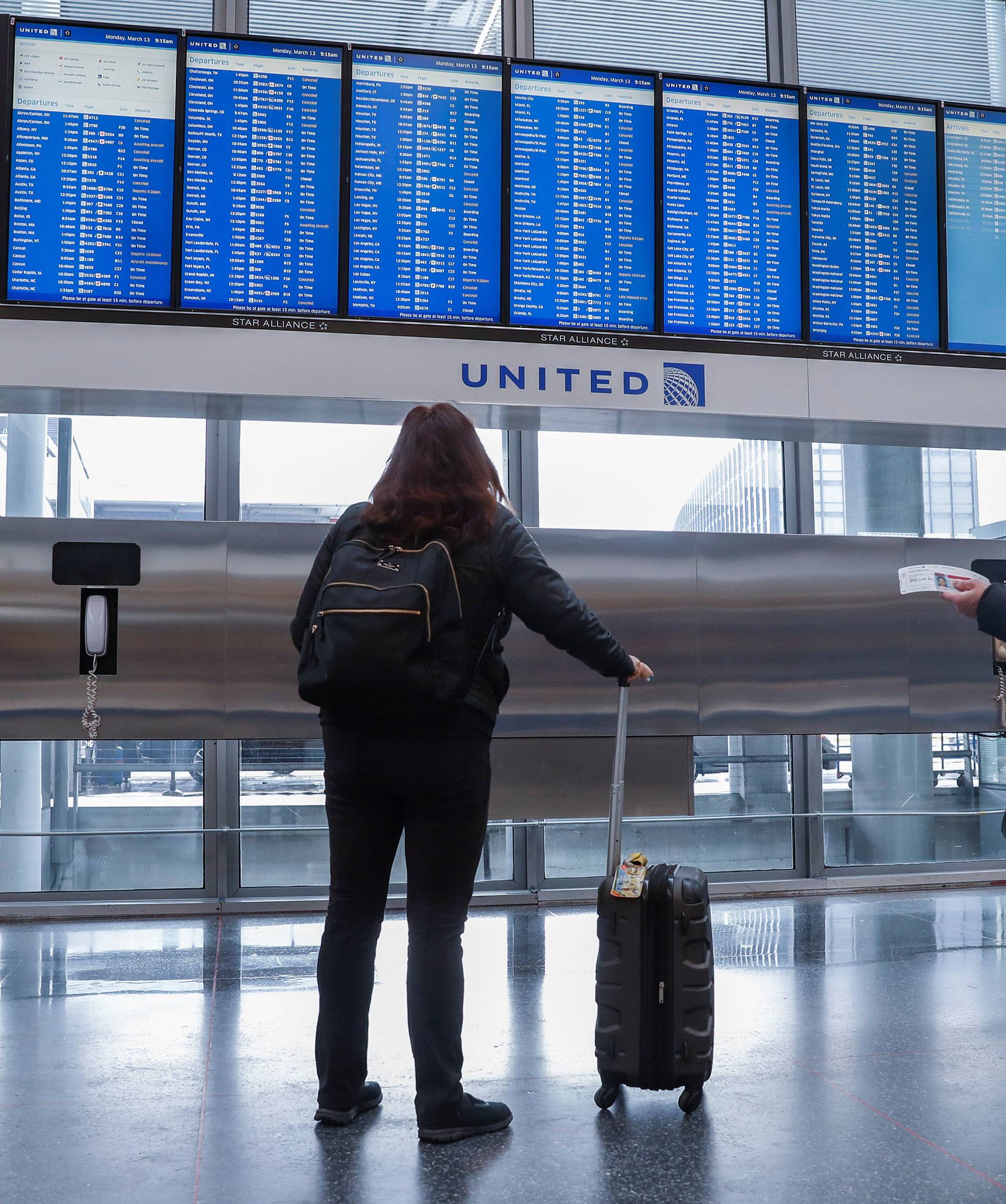 Travelers check the departure board at O'Hare International Airport in Chicago